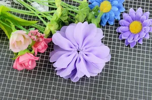 Close-up of handmade wavy chiffon flower with mini roses and daisies for DIY crafts