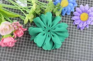 Macro detail of dark green hand-sewn chiffon wave flower for DIY hair accessories