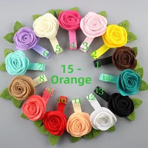 Vue à plat de 15 pinces à cheveux roses colorées avec fleurs en feutrine et ruban gros-grain
