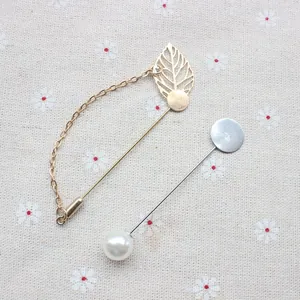 Set spilla a foglia d'oro e spilla di perle per abiti su sfondo di tessuto a fiori