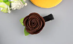 Détail d'une pince à cheveux rose en feutre marron fait main avec feuilles sur clip métallique