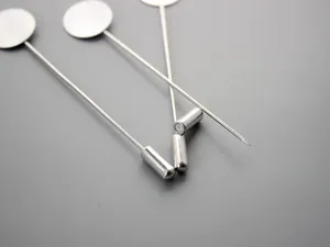 Dettaglio macro della spilla da bavero in acciaio inox argento con disco e chiusura