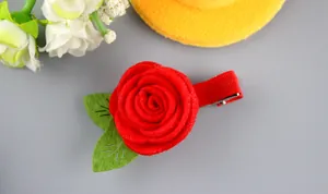 Détail d'une pince à cheveux rose rouge en feutrine faite main avec feuilles et clip métal