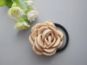Detailed close-up of a champagne satin rose hair scrunchie with high elastic black band