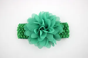 Detailed view of large green chiffon flower on a crochet baby headband accessory