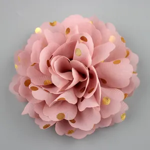 Macro detail of pink chiffon flower brooch with golden foil dots and layered petals