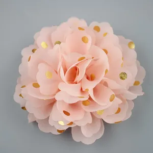 Detail of handmade chiffon flower accessory with gold foil dots in soft peach pink color
