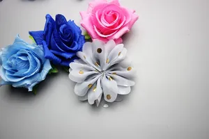 Detail of handmade chiffon fabric flowers with gold polka dots in blue, pink, and grey