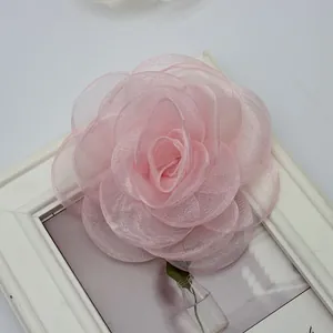 Dettaglio di una rosa fatta a mano in organza rosa in un piccolo vaso di vetro