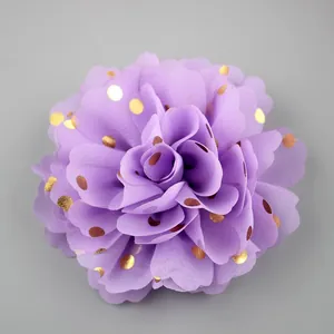 Macro detail of purple chiffon flower brooch with golden dots and layered petals