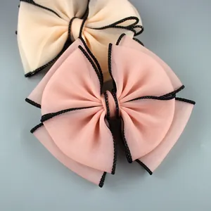 Close-up of double-layer organza bow hair accessories with fine black stitched edges