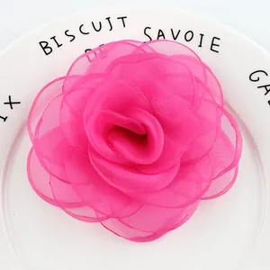 Vista macro di una spilla rosa fatta a mano da 10cm in tessuto magenta con petali pizzo
