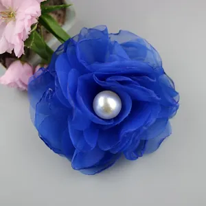 Macro shot of dark blue satin flower hair accessory with white center pearl detail