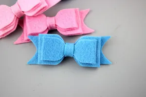 Detailed view of layered felt bow hair clips in vibrant pink and sky blue colors