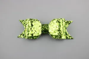 Detail of bright green glitter bow hair accessory with shimmering sequin texture finish