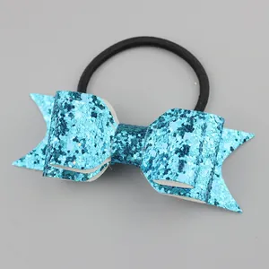 Detail of glittery turquoise sequin bow hair tie with high-shine texture and black elastic band