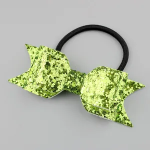Detailed macro view of girls' glitter bow hair tie with green sequins and elastic band