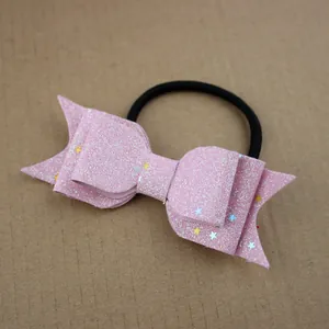Pink glitter bow hair tie with star sequins for girls on a neutral textured background
