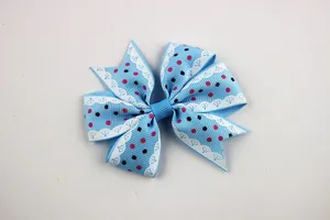 Close-up of blue polka dot ribbed ribbon hair bow with white lace trim for DIY crafts