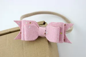 Detail van een roze glitter haarband voor baby's met sterren op een zachte nylon band