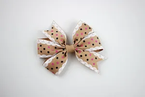 Detailed view of a brown polka dot ribbon bow with elegant white lace edge trim