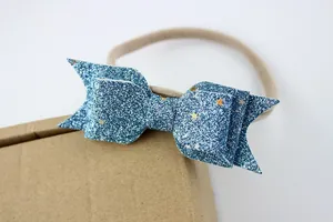 Detailopname van een blauwe glitter strik haarband met gekleurde sterren voor baby's en kids