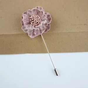 Detail of flower lapel pin with textured pink fabric petals and silver long needle