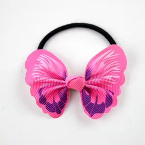 Close-up of pink ribbon bow hair tie with purple patterns and elastic black band