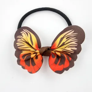 Detail of a ribbed fabric butterfly hair tie with red and yellow wing patterns