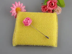 Macro detail of the handmade pink satin rose lapel pin with a silver long metal needle