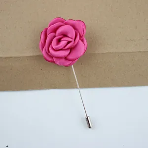 Dettaglio macro della spilla fatta a mano in tessuto rosa rossa con ago lungo d'argento