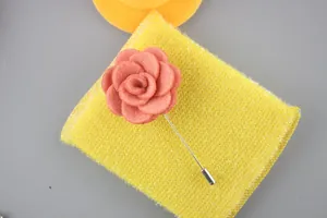 Macro shot of handcrafted coral pink fabric flower lapel pin with silver metal stick