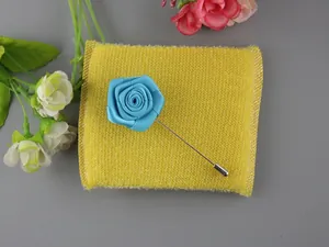 Dettaglio del fiore all'occhiello in raso blu con spilla lunga in metallo argentato