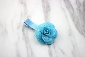 Dettaglio di un fermaglio per capelli a rosa 3D blu su sfondo in finto marmo