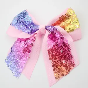 Detailed view of pink bow hair clip featuring colorful gradient sequins and ribbon texture