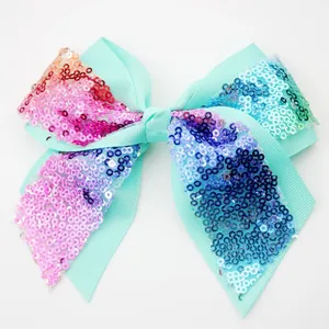 Detail of mint green hair clip with colorful sequins and grosgrain ribbon texture