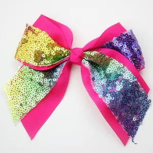 Detail of hot pink bow hair clip with colorful gradient sequins and ribbon texture