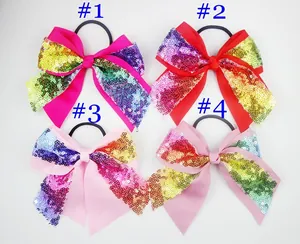Close-up of four sequined bow hair ties in pink and red tones on elastic bands