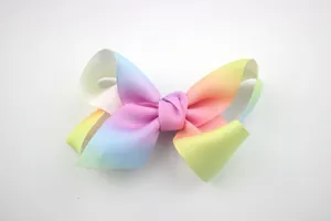 Macro detail of a large rainbow gradient grosgrain ribbon hair bow for girls