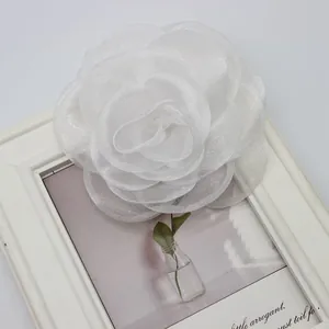 Dettaglio di una rosa in pizzo bianco da 10cm fatta a mano con strati di tessuto organza