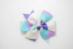 Detailed view of the layered rainbow gradient grosgrain ribbon bow with geometric print