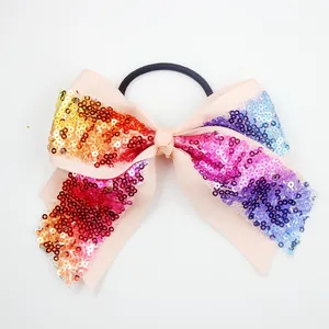Detail of glitter sequins bow hair tie with rainbow gradient on pink ribbed ribbon