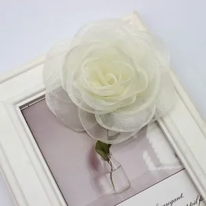 Vista dettagliata di una rosa in organza bianca fatta a mano su una cornice vintage