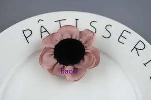 Detailed back view of handmade fabric flower showing black felt center for crafts