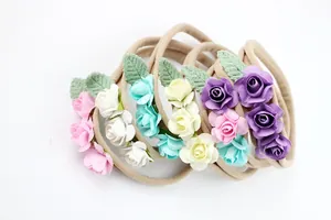Detailed close-up of mini fabric roses and leaves on soft elastic baby nylon headbands