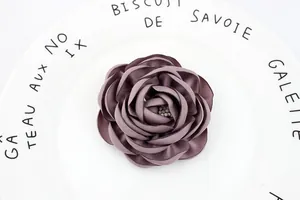 Detailed view of handmade 7.5cm mauve fabric camellia flower with bead stamen