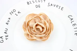 Close-up of a handmade 3D camellia fabric flower featuring realistic stamen details and burnt edges