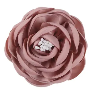 Macro detail of dusty pink fabric camellia flower with layered petals and white stamen
