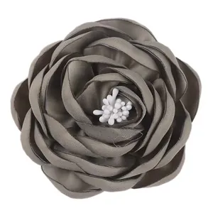 Macro shot of 7.5cm handmade gray fabric camellia with realistic white stamen detail