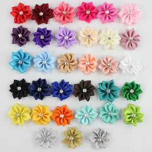 Flat lay of colorful DIY polyester ribbon flowers with rhinestones for craft accessories